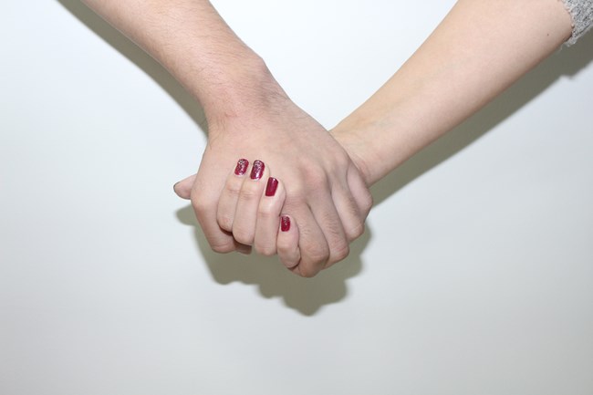 手 を 繋ぐ 指 を 動かす 女性